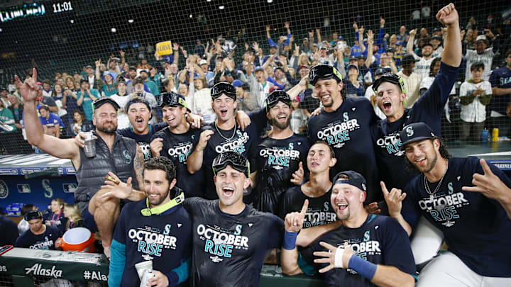 Seattle Mariners players and staff, including relief pitcher Matthew Boyd (first row, second from left) and catcher Cal Raleigh (first row second from right) celebrate in the dugout following a 2-1 victory against the Oakland Athletics to clinch a wild card playoff berth at T-Mobile Park in 2022.