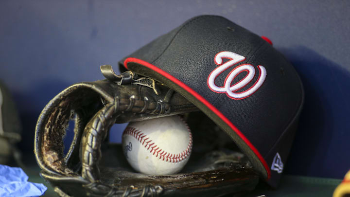 Apr 11, 2022; Atlanta, Georgia, USA; A detailed view of a Washington Nationals hat and glove in the dugout before a game against the Atlanta Braves at Truist Park. Mandatory Credit: Brett Davis-Imagn Images
