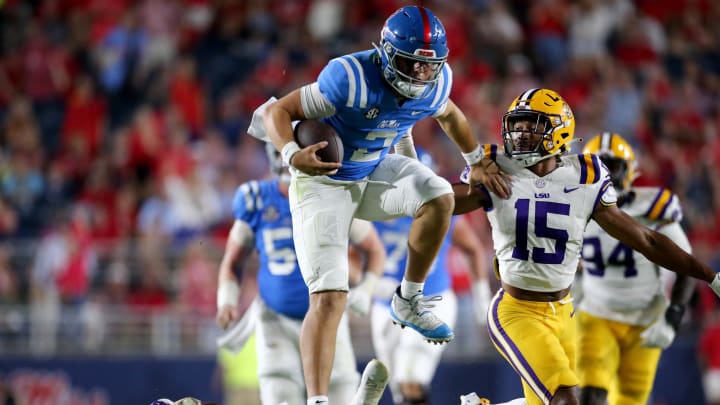 Sep 30, 2023; Oxford, Mississippi, USA; Mississippi Rebels quarterback Jaxson Dart (2) leaps over LSU Tigers defensive back Andre' Sam (14) during the second half at Vaught-Hemingway Stadium. Mandatory Credit: Petre Thomas-USA TODAY Sports