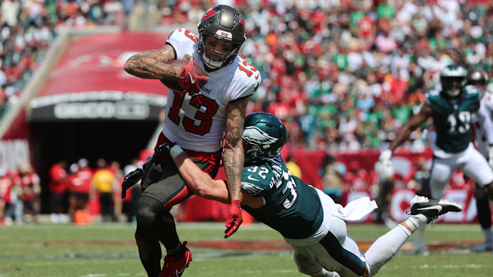 Sep 29, 2024; Tampa, Florida, USA; Tampa Bay Buccaneers wide receiver Mike Evans (13) runs with the ball as Philadelphia Eagles safety Reed Blankenship (32) defends during the first half at Raymond James Stadium. Mandatory Credit: Kim Klement Neitzel-Imagn Images