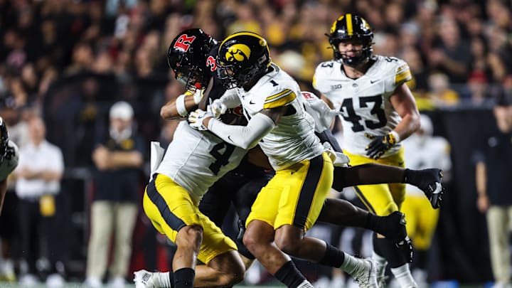 Sep 19, 2025; Piscataway, New Jersey, USA; Rutgers Scarlet Knights running back Antwan Raymond (3) is tackled by Iowa Hawkeyes defensive back Koen Entringer (4) and defensive back Xavier Nwankpa (1) during the first half at SHI Stadium. Mandatory Credit: Vincent Carchietta-Imagn Images