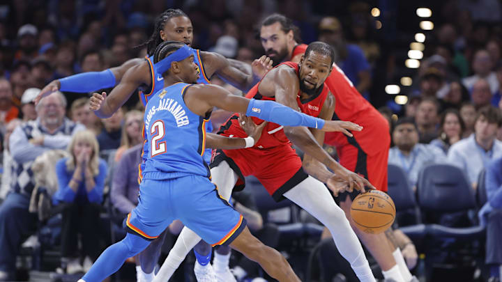 Oct 21, 2025; Oklahoma City, Oklahoma, USA; Houston Rockets forward Kevin Durant (7) passes around Oklahoma City Thunder guard Shai Gilgeous-Alexander (2) during the first half at Paycom Center. Mandatory Credit: Alonzo Adams-Imagn Images