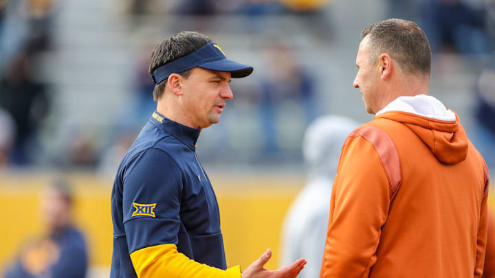 Nov 20, 2021; Morgantown, West Virginia, USA; West Virginia Mountaineers head coach Neal Brown talks with Texas Longhorns head coach Steve Sarkisian before the game at Mountaineer Field at Milan Puskar Stadium. Mandatory Credit: Ben Queen-Imagn Images