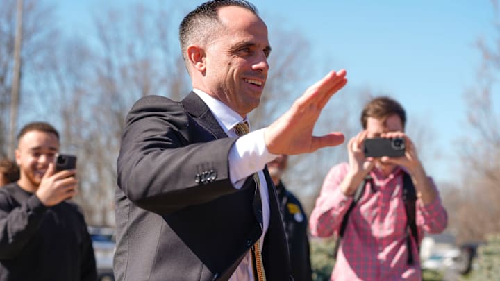 Iowa's new head men's basketball coach Ben McCollum waves at the assembled crowd while walking into his introductory press conference Tuesday, March 25, 2025 at Carver-Hawkeye Arena in Iowa City, Iowa.