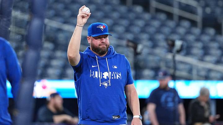 Toronto Blue Jays manager John Schneider walks onto the field during batting practice. 