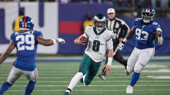 Jan 7, 2024; East Rutherford, New Jersey, USA; Philadelphia Eagles quarterback Marcus Mariota (8) carries the ball as New York Giants defensive tackle Rakeem Nunez-Roches (93) and safety Xavier McKinney (29) pursue during the second half at MetLife Stadium. Mandatory Credit: Vincent Carchietta-USA TODAY Sports