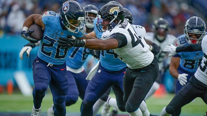 Jacksonville Jaguars defensive end Travon Walker (44) tries to wrap up Tennessee Titans running back Tony Pollard (20) during the third quarter at Nissan Stadium in Nashville, Tenn., Sunday, Dec. 8, 2024.