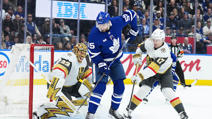 Jan 23, 2026; Toronto, Ontario, CAN; Toronto Maple Leafs center Nicolas Roy (55) battles for the puck with Vegas Golden Knights defenseman Ben Hutton (17) during the first period at Scotiabank Arena. Mandatory Credit: Nick Turchiaro-Imagn Images