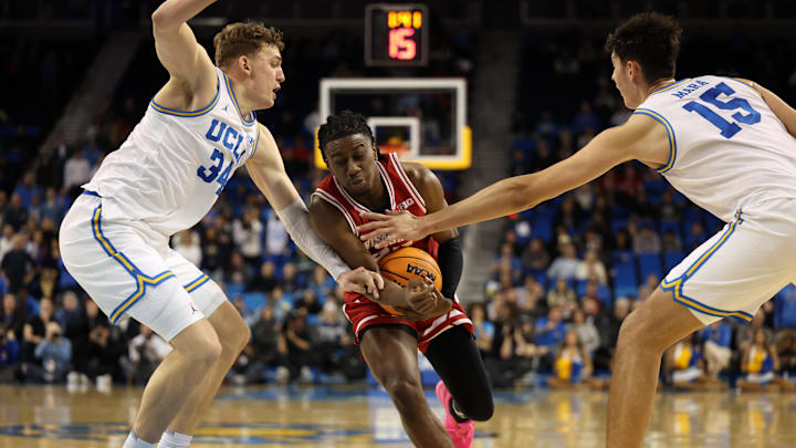 Jan 21, 2025; Los Angeles, California, USA;  Wisconsin Badgers guard John Blackwell (25) drives to the basket between UCLA Bruins forward Tyler Bilodeau (34) and UCLA Bruins center Aday Mara (15) during the second half at Pauley Pavilion presented by Wescom. Mandatory Credit: Kiyoshi Mio-Imagn Images