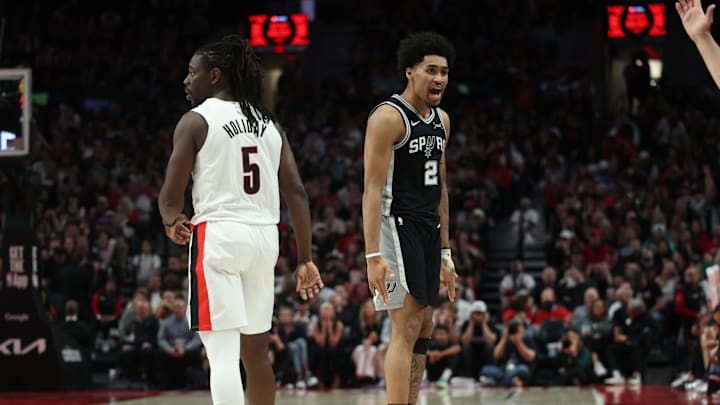 San Antonio Spurs guard Dylan Harper reacts after scoring against Portland Trail Blazers guard Jrue Holiday during the second half during game three of the first round of the 2026 NBA Playoffs at Moda Center. Mandatory Credit: Jaime Valdez-Imagn Images