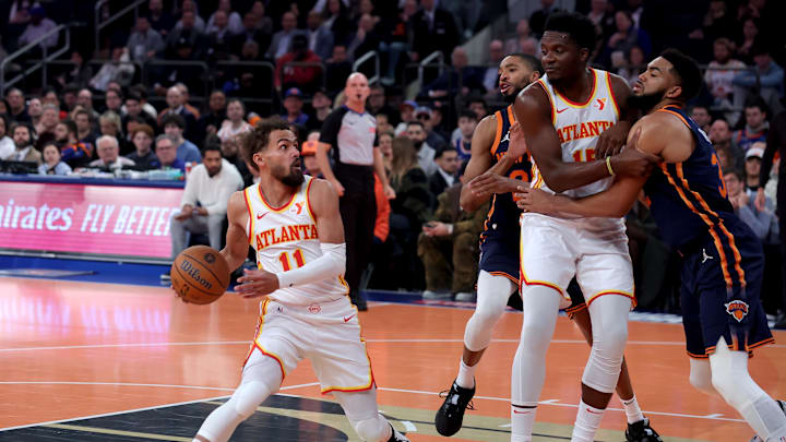 Dec 11, 2024; New York, New York, USA; Atlanta Hawks guard Trae Young (11) drives to the basket against New York Knicks forward Mikal Bridges (25) and center Karl-Anthony Towns (32) during the first quarter at Madison Square Garden. Mandatory Credit: Brad Penner-Imagn Images