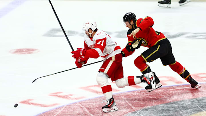 Feb 26, 2026; Ottawa, Ontario, CAN; Detroit Red Wings center Dylan Larkin (71) and Ottawa Senators defenseman Jake Sanderson (85) chase the puck during the third period at Canadian Tire Centre. Mandatory Credit: Keito Newman-Imagn Images