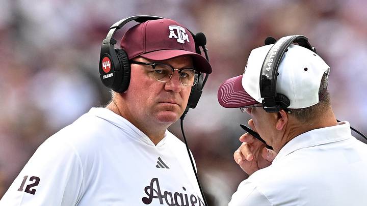 Texas A&M Aggies head coach Mike Elko speaks with a member of his coaching staff during a time-out in the fourth quarter against the Kentucky Wildcats at Kyle Field. Texas A&M Aggies head coach Mike Elko speaks with a member of his coaching staff during a time-out in the fourth quarter against the Kentucky Wildcats at Kyle Field.