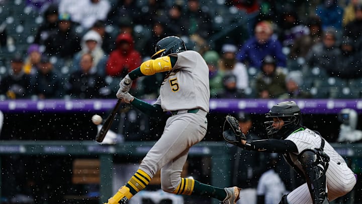 Apr 4, 2025; Denver, Colorado, USA; Athletics shortstop Jacob Wilson (5) hits a two RBI single in the eleventh inning against the Colorado Rockies at Coors Field. Mandatory Credit: Isaiah J. Downing-Imagn Images