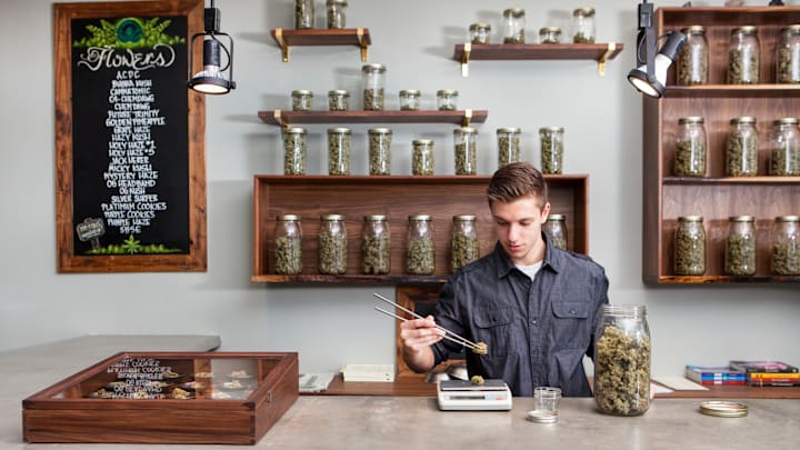 A “budtender” measuring out marijuana.