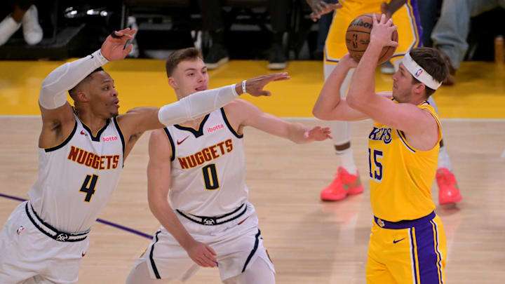 Mar 19, 2025; Los Angeles, California, USA; Denver Nuggets guard Russell Westbrook (4) and guard Christian Braun (0) defend as shot by Los Angeles Lakers guard Austin Reaves (15) in the first half at Crypto.com Arena. Mandatory Credit: Jayne Kamin-Oncea-Imagn Images