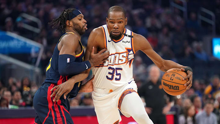 Jan 31, 2025; San Francisco, California, USA; Phoenix Suns forward Kevin Durant (35) dribbles the ball next to Golden State Warriors guard Buddy Hield (7) in the first quarter at the Chase Center.