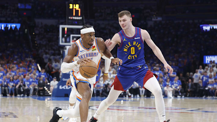 May 13, 2025; Oklahoma City, Oklahoma, USA; Oklahoma City Thunder guard Shai Gilgeous-Alexander (2) drives to the basket beside Denver Nuggets guard Christian Braun (0) during the second half of game five of the second round for the 2025 NBA Playoffs at Paycom Center. Mandatory Credit: Alonzo Adams-Imagn Images