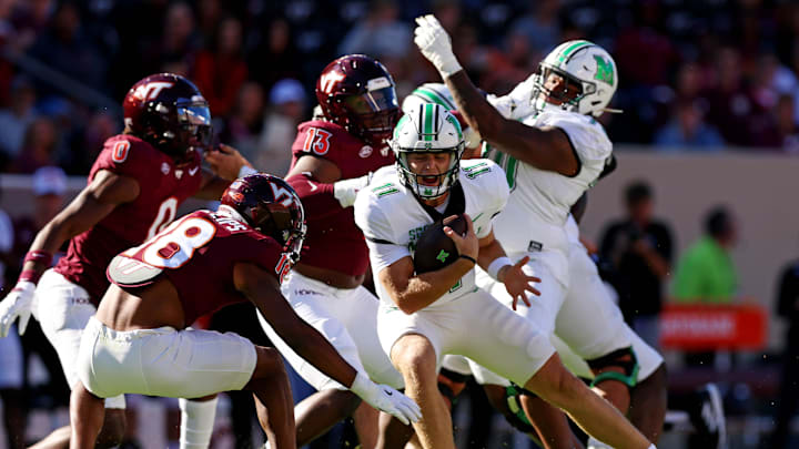 Sep 7, 2024; Blacksburg, Virginia, USA; Marshall Thundering Herd quarterback Stone Earle (11) runs the ball against Virginia Tech Hokies safety Mose Phillips III (18) during the first quarter at Lane Stadium. Mandatory Credit: Peter Casey-Imagn Images