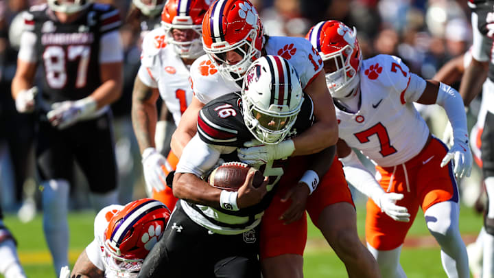 Nov 29, 2025; Columbia, South Carolina, USA; South Carolina Gamecocks quarterback Lanorris Sellers (16) is stopped for a loss by Clemson Tigers defensive end Will Heldt (13) in the first quarter at Williams-Brice Stadium. Mandatory Credit: Jeff Blake-Imagn Images