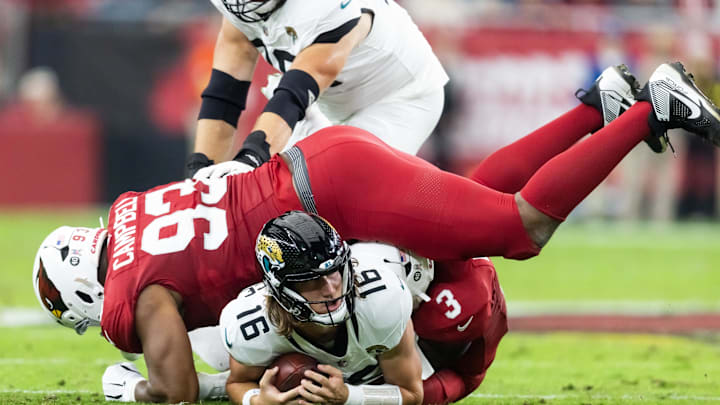 Nov 23, 2025; Glendale, Arizona, USA; Jacksonville Jaguars quarterback Trevor Lawrence (16) is tackled by Arizona Cardinals defensive lineman Calais Campbell (93) in the first half at State Farm Stadium. Mandatory Credit: Mark J. Rebilas-Imagn Images