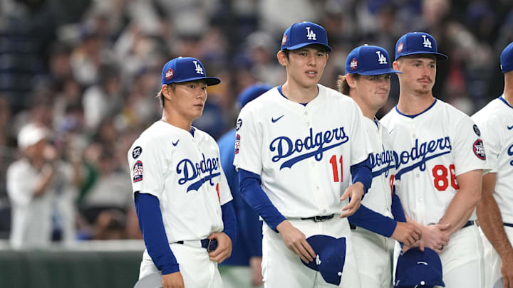 Bunkyo, Tokyo, Japan; Los Angeles Dodgers pitcher Yoshinobu Yamamoto (left) and pitcher Roki Sasaki (center right) stand on the field before the game against the Hanshin Tigers at Tokyo Dome.