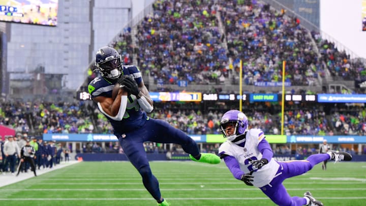 Dec 22, 2024; Seattle, Washington, USA; Seattle Seahawks wide receiver DK Metcalf (14) catches a pass for a touchdown while defended by Minnesota Vikings cornerback Stephon Gilmore (2) during the first half at Lumen Field. Mandatory Credit: Steven Bisig-Imagn Images