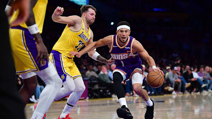Dec 1, 2025; Los Angeles, California, USA; Phoenix Suns guard Devin Booker (1) moves to the basket against Los Angeles Lakers guard Luka Doncic (77) during the first half at Crypto.com Arena. Mandatory Credit: Gary A. Vasquez-Imagn Images