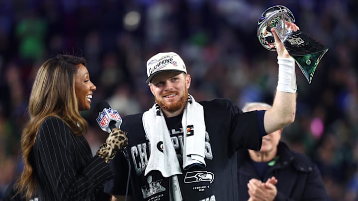 Feb 8, 2026; Santa Clara, CA, USA; Seattle Seahawks quarterback Sam Darnold (14) celebrates with the Vince Lombardi trophy on the podium after defeating the New England Patriots in Super Bowl LX at Levi's Stadium. Mandatory Credit: Mark J. Rebilas-Imagn Images