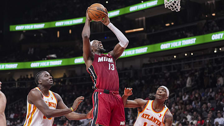 Feb 24, 2025; Atlanta, Georgia, USA; Miami Heat center Bam Adebayo (13) goes to the basket between Atlanta Hawks center Clint Capela (15) and guard Terance Mann (14) during the first half at State Farm Arena. Mandatory Credit: Dale Zanine-Imagn Images
