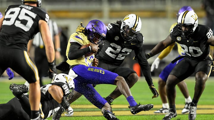 Sep 7, 2024; Nashville, Tennessee, USA;  Vanderbilt Commodores linebacker Bryce Cowan (22) and defensive lineman Devin Lee (99) tackle Alcorn State Braves quarterback Xzavier Vaughn (15) for a loss during the second half at FirstBank Stadium. Mandatory Credit: Steve Roberts-Imagn Images