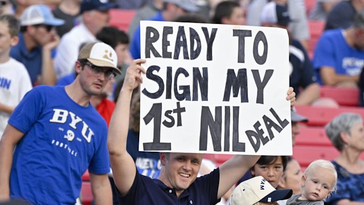 A view of a fan holding up an NIL sign during the first half of the game between the Southern Methodist Mustangs and the Brigham Young Cougars at Gerald J. Ford Stadium. A view of a fan holding up an NIL sign during the first half of the game between the Southern Methodist Mustangs and the Brigham Young Cougars at Gerald J. Ford Stadium.