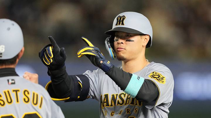 Mar 15, 2025; Bunkyo, Tokyo, Japan; Hanshin Tigers right fielder Teruaki Sato (8) gestures after hitting an RBI-single against the Chicago Cubs during the fifth inning at Tokyo Dome. Mandatory Credit: Darren Yamashita-Imagn Images