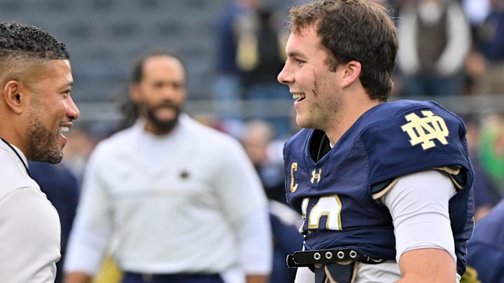 Nov 16, 2024; South Bend, Indiana, USA; Notre Dame Fighting Irish head coach Marcus Freeman greets quarterback Riley Leonard (13) before the game against the Virginia Cavaliers at Notre Dame Stadium. 