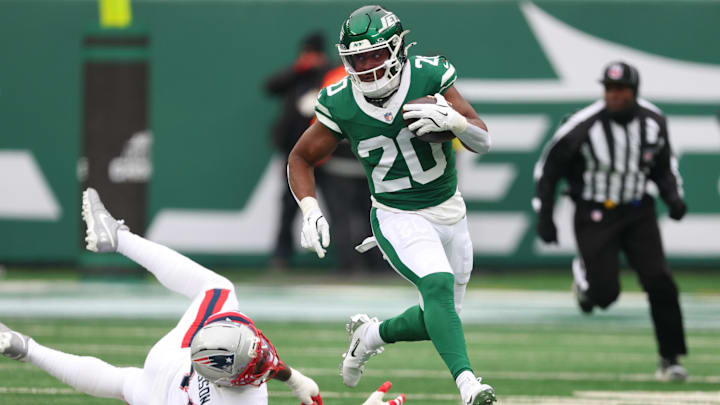 Dec 28, 2025; East Rutherford, New Jersey, USA; New York Jets running back Breece Hall (20) runs the ball against New England Patriots linebacker K'Lavon Chaisson (44) during the second quarter of the game at MetLife Stadium. Mandatory Credit: Vincent Carchietta-Imagn Images