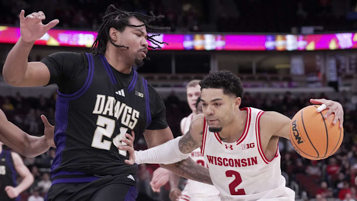 Mar 12, 2026; Chicago, IL, USA; Wisconsin Badgers guard Nick Boyd (2) drives on Washington Huskies center Lathan Sommerville (24) during the first half of their third round game of the Big Ten tournament at United Center. 