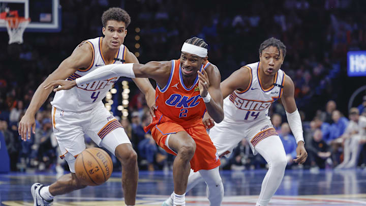 Nov 15, 2024; Oklahoma City, Oklahoma, USA; Oklahoma City Thunder guard Shai Gilgeous-Alexander (2), Phoenix Suns center Oso Ighodaro (4) and guard TyTy Washington Jr. (14) chase after a loose ball during the fourth quarter at Paycom Center. Mandatory Credit: Alonzo Adams-Imagn Images