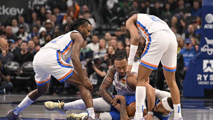Jan 17, 2025; Dallas, Texas, USA; Oklahoma City Thunder forward Jaylin Williams (6) and Dallas Mavericks center Daniel Gafford (21) battle for control of the loose ball during the first quarter at the American Airlines Center. Mandatory Credit: Jerome Miron-Imagn Images