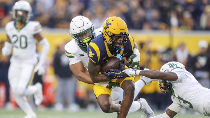 Nov 16, 2024; Morgantown, West Virginia, USA; West Virginia Mountaineers wide receiver Traylon Ray (7) catches a pass and is tackled by Baylor Bears linebacker Keaton Thomas (11) during the first quarter at Mountaineer Field at Milan Puskar Stadium. Mandatory Credit: Ben Queen-Imagn Images