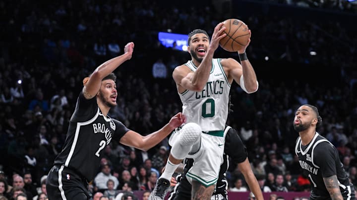 Mar 15, 2025; Brooklyn, New York, USA; Boston Celtics forward Jayson Tatum (0) drives past Brooklyn Nets forward Cameron Johnson (2) and guard D'Angelo Russell (1) during the second half at Barclays Center. Mandatory Credit: John Jones-Imagn Images