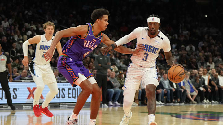 Nov 18, 2024; Phoenix, Arizona, USA; Orlando Magic guard Kentavious Caldwell-Pope (3) drives on Phoenix Suns center Oso Ighodaro (4)during the second half of an NBA game at Footprint Center. Mandatory Credit: Rick Scuteri-Imagn Images