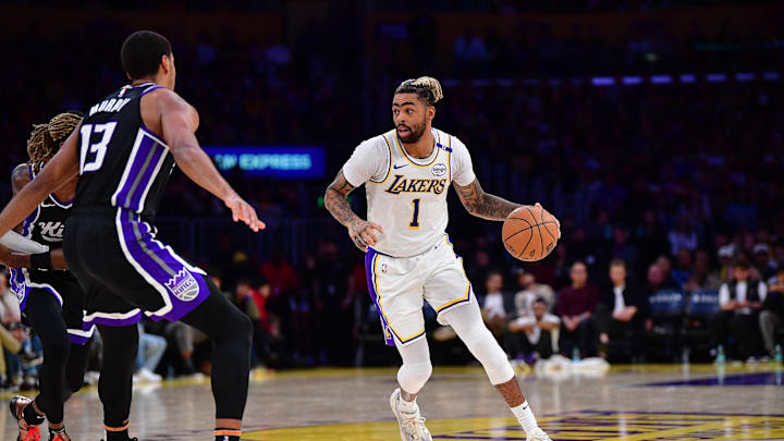 Dec 28, 2024; Los Angeles, California, USA; Los Angeles Lakers guard D'Angelo Russell (1) moves the ball against Sacramento Kings forward Keegan Murray (13) during the second half at Crypto.com Arena. Mandatory Credit: Gary A. Vasquez-Imagn Images