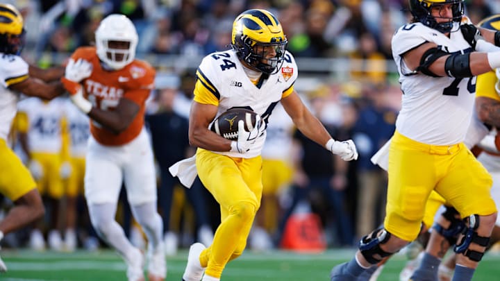 Dec 31, 2025; Orlando, FL, USA; Michigan Wolverines running back Bryson Kuzdzal (24) rushes with the ball against the Texas Longhorns during the first half at Camping World Stadium. Mandatory Credit: Matt Pendleton-Imagn Images