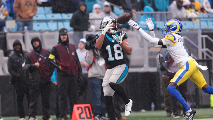 Nov 30, 2025; Charlotte, North Carolina, USA; Carolina Panthers wide receiver Jalen Coker (18) makes a catch as Los Angeles Rams cornerback Emmanuel Forbes Jr. (1) defends during the third quarter at Bank of America Stadium. Mandatory Credit: Scott Kinser-Imagn Images