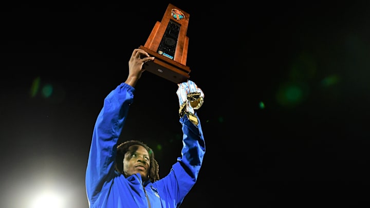 Miami Northwestern coach Teddy Bridgewater raises the state trophy.