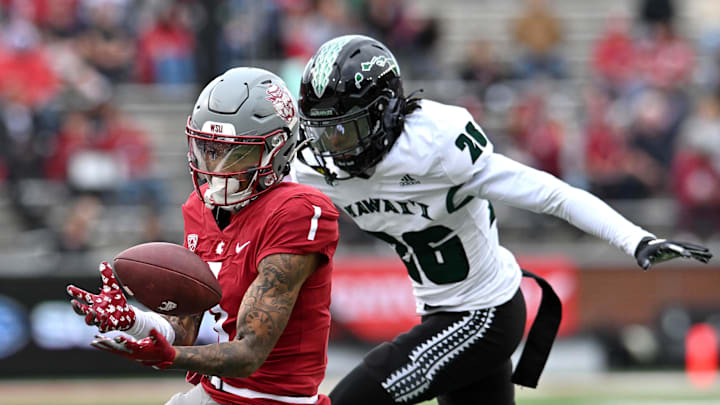 Oct 19, 2024; Pullman, Washington, USA; Washington State Cougars wide receiver Kris Hutson (1) makes a juggling catch against Hawaii Warriors defensive back Deliyon Freeman (26) in the second half at Gesa Field at Martin Stadium. Washington State won 42-10. Mandatory Credit: James Snook-Imagn Images