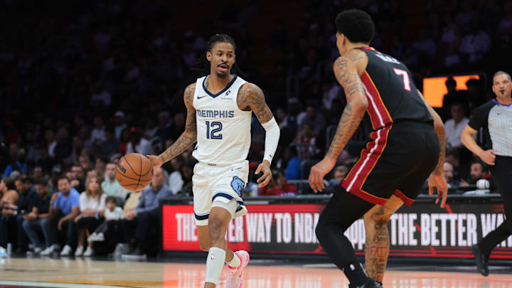 Apr 3, 2025; Miami, Florida, USA; Memphis Grizzlies guard Ja Morant (12) dribbles the basketball as Miami Heat center Kel'el Ware (7) defends during the first quarter at Kaseya Center. Mandatory Credit: Sam Navarro-Imagn Images