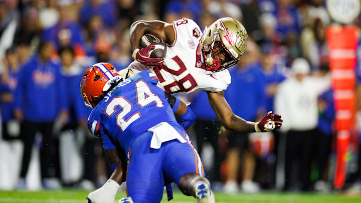 Nov 29, 2025; Gainesville, Florida, USA; Florida Gators defensive end Kamran James (24) tackles Florida State Seminoles running back Samuel Singleton Jr. (28) during the second half at Ben Hill Griffin Stadium. Mandatory Credit: Matt Pendleton-Imagn Images