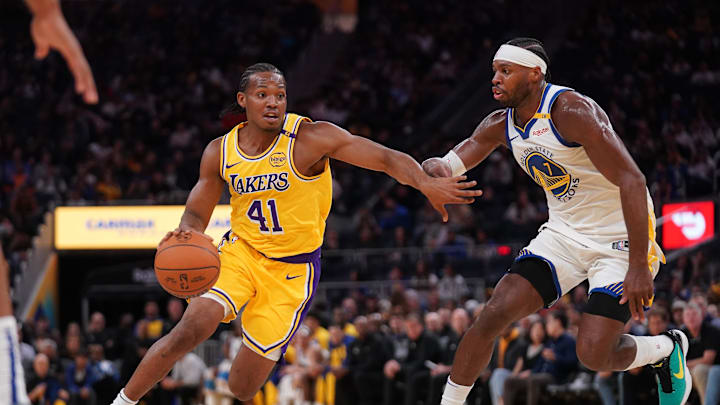 Oct 18, 2024; San Francisco, California, USA; Los Angeles Lakers guard Quincy Olivari (41) dribbles past Golden State Warriors guard Buddy Hield (7) in the second quarter at the Chase Center. Mandatory Credit: Cary Edmondson-Imagn Images
