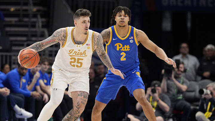 Mar 11, 2025; Charlotte, NC, USA; Notre Dame Fighting Irish forward Nikita Konstantynovskyi (25) handles the ball against Pittsburgh Panthers forward Cameron Corhen (2) during the first half at Spectrum Center. Mandatory Credit: Jim Dedmon-Imagn Images